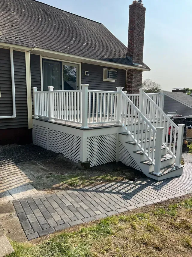A house with a deck and stairs in front of it.