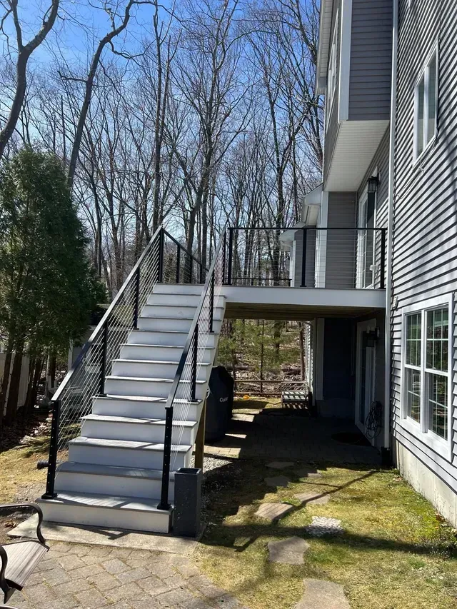 A house with a deck and stairs leading up to it.