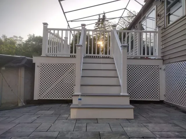 A white deck with stairs leading up to it.
