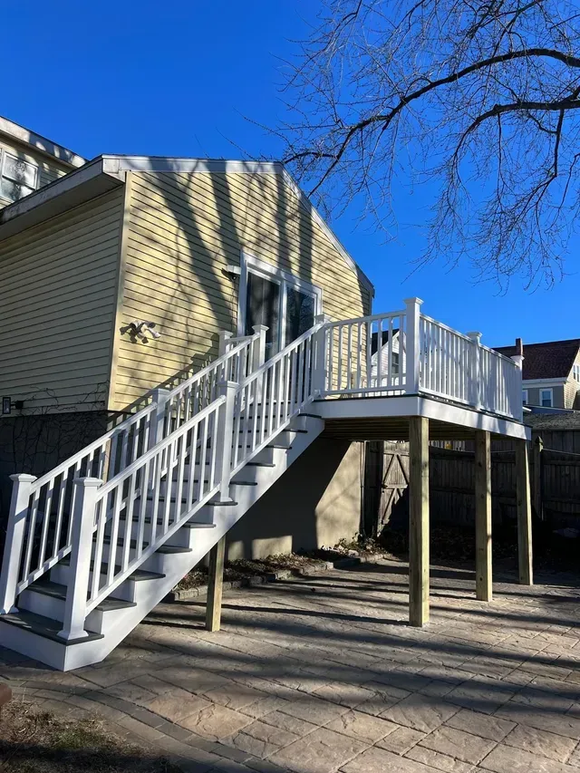 A house with a deck and stairs leading up to it.