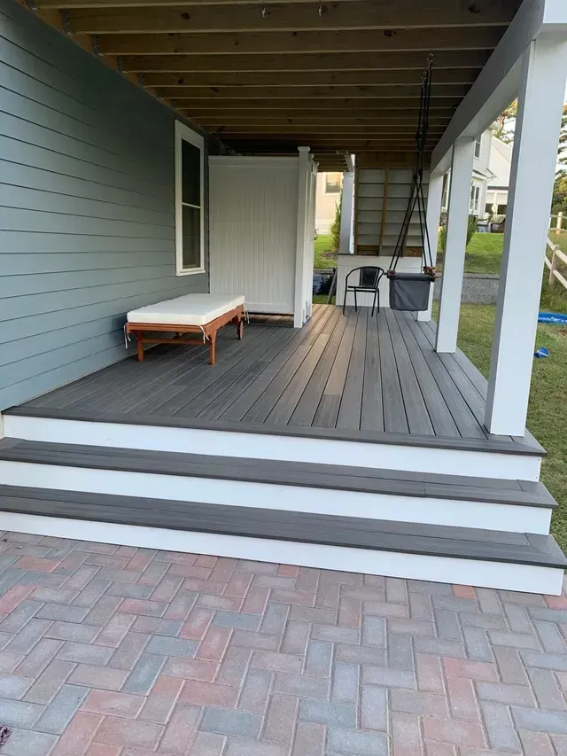A deck with stairs and a bench on it.