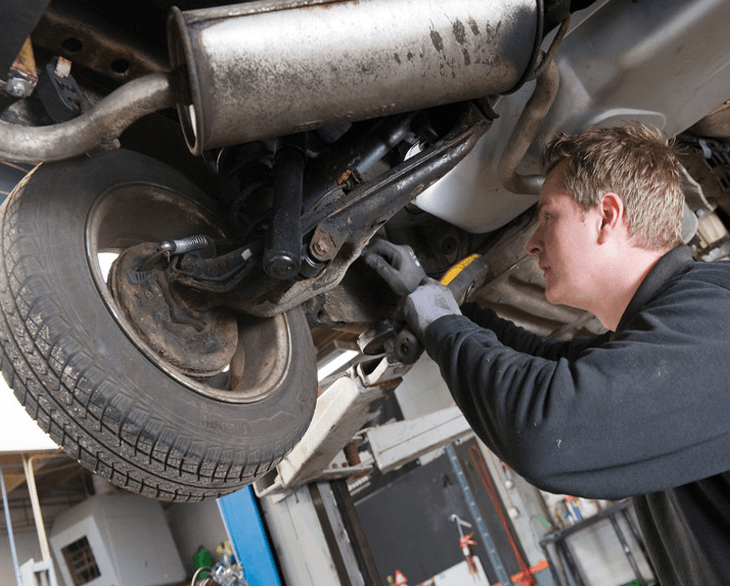 man fixing suspension in a car
