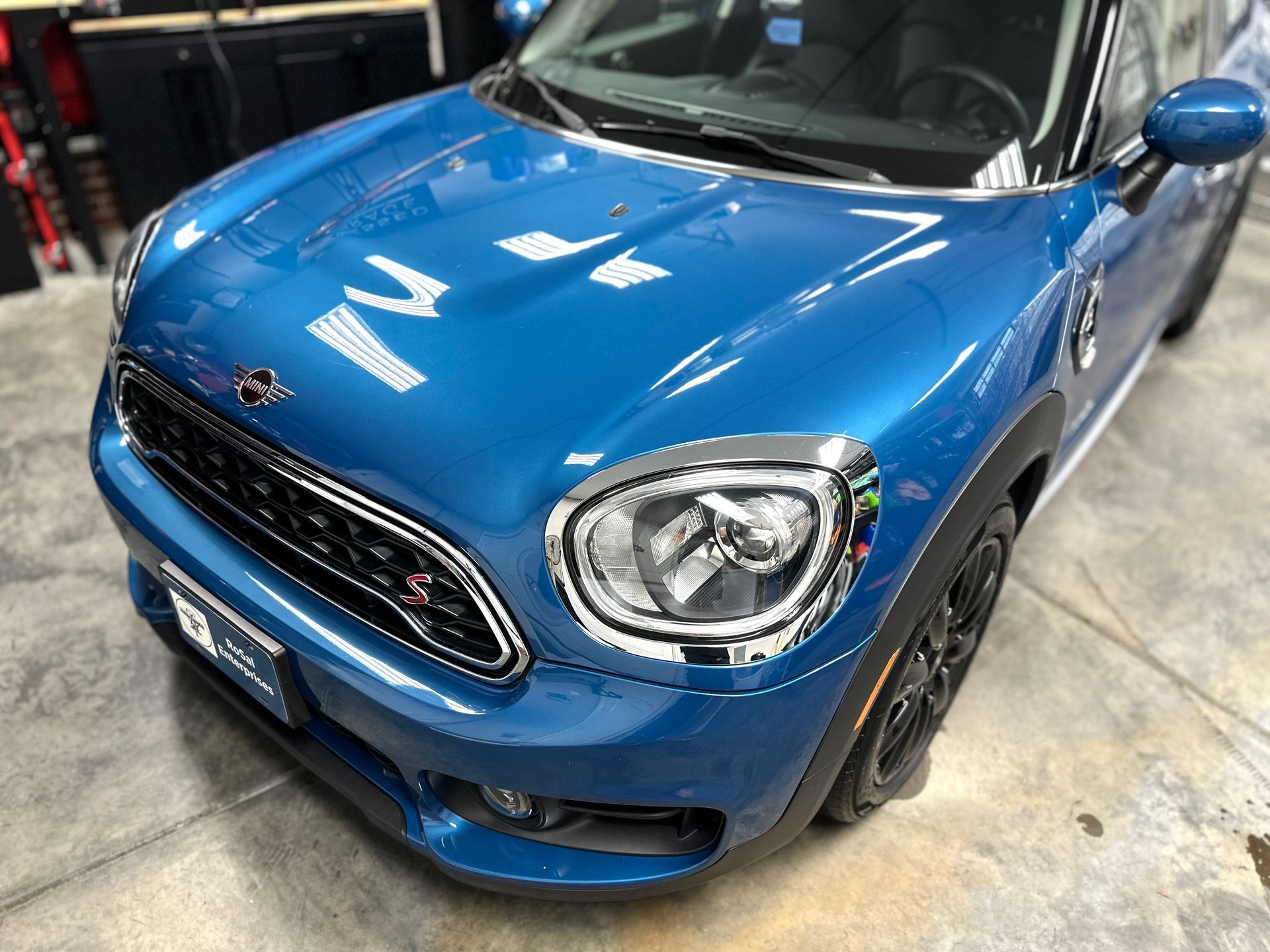 Blue Mini Cooper Countryman parked in a garage.