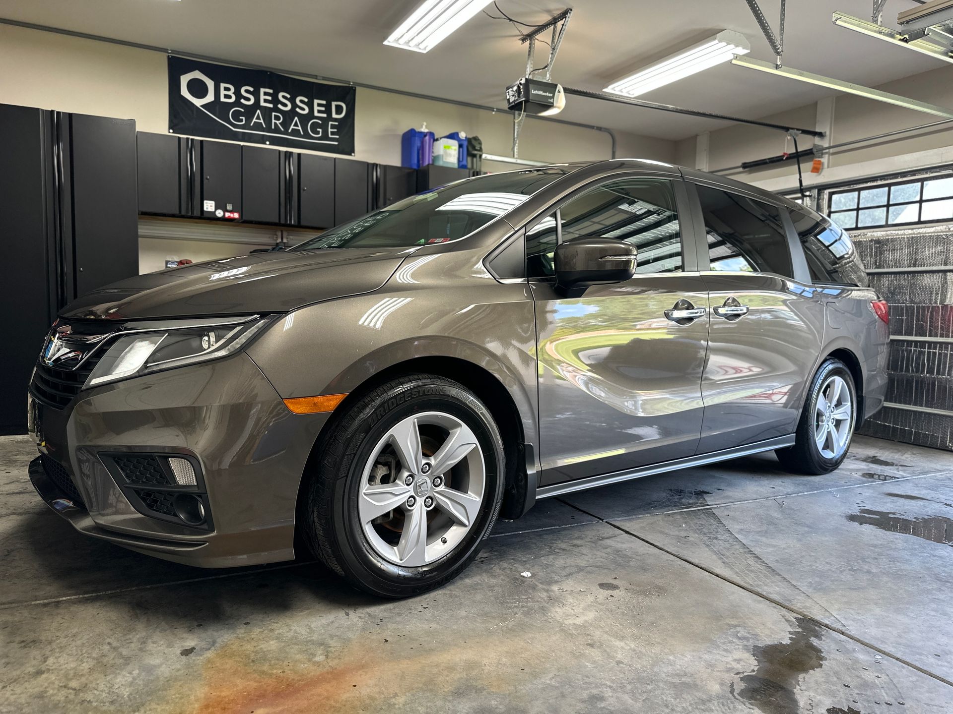 Brown Honda Odyssey minivan parked inside a garage. 