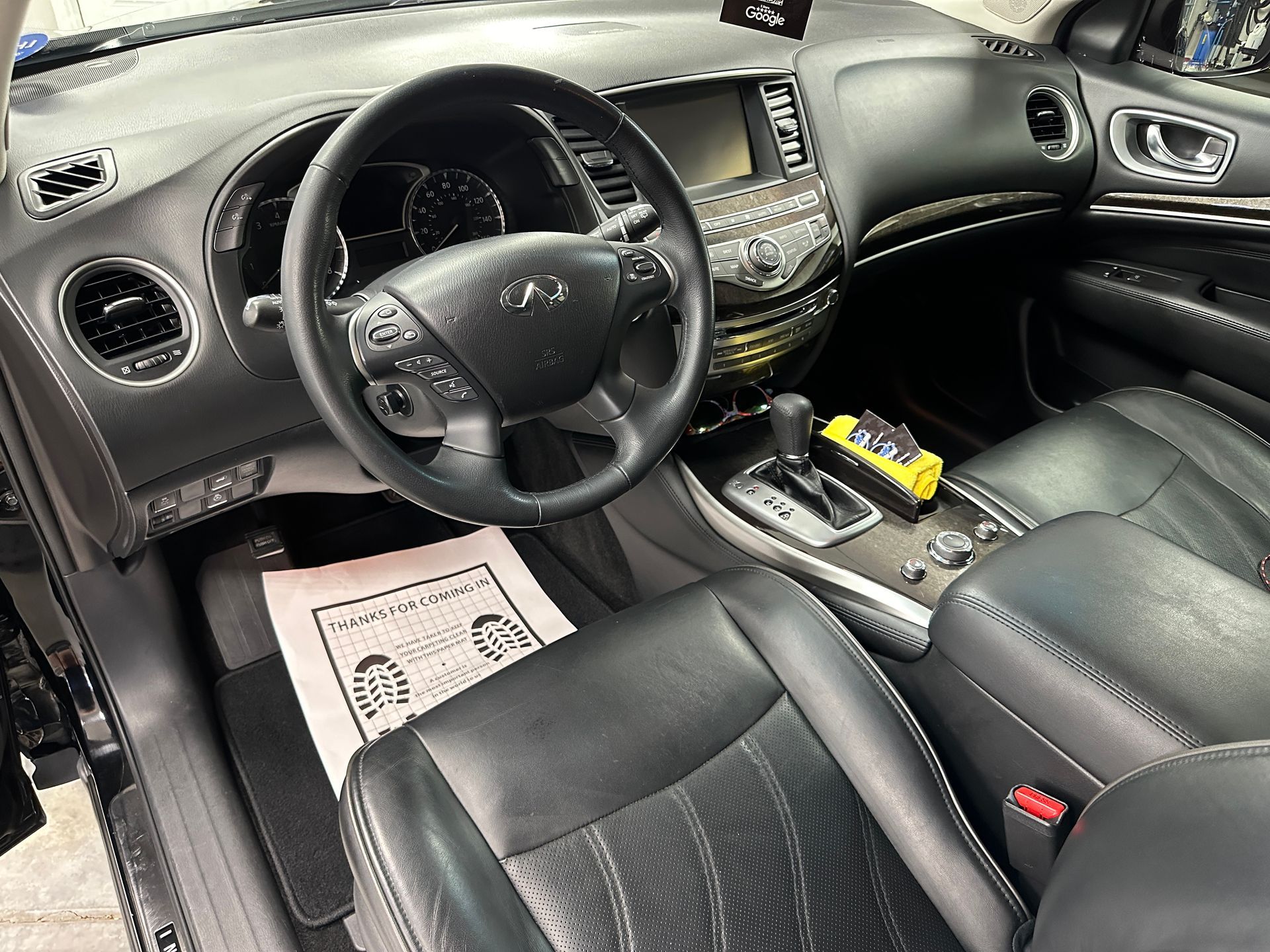 Black interior of a car, including the steering wheel, dashboard, and driver's seat.