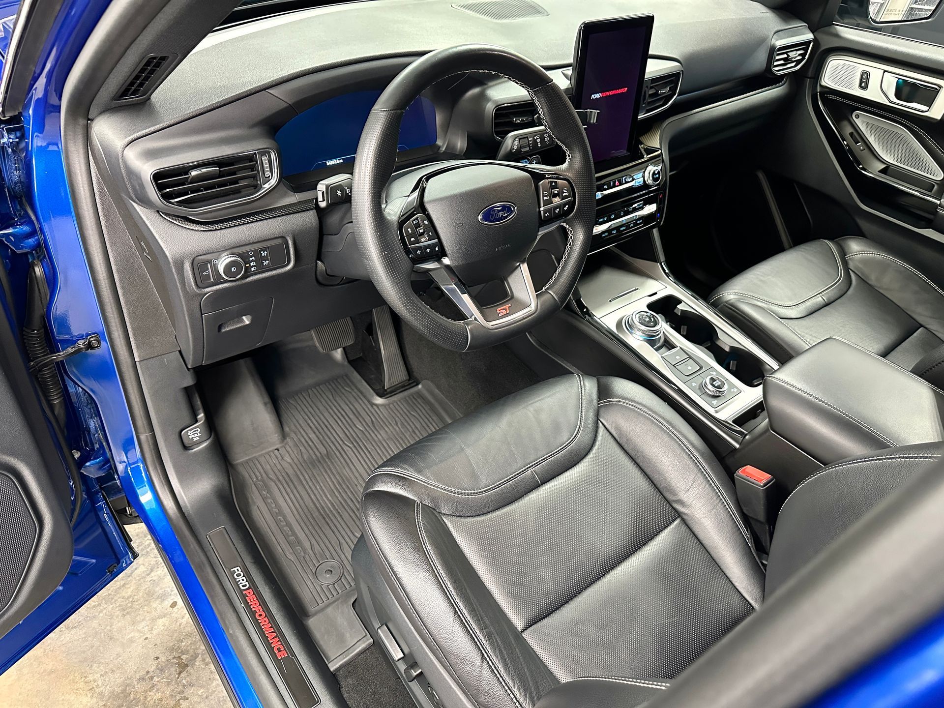 Blue Ford Explorer interior with black leather seats, steering wheel, and dashboard.