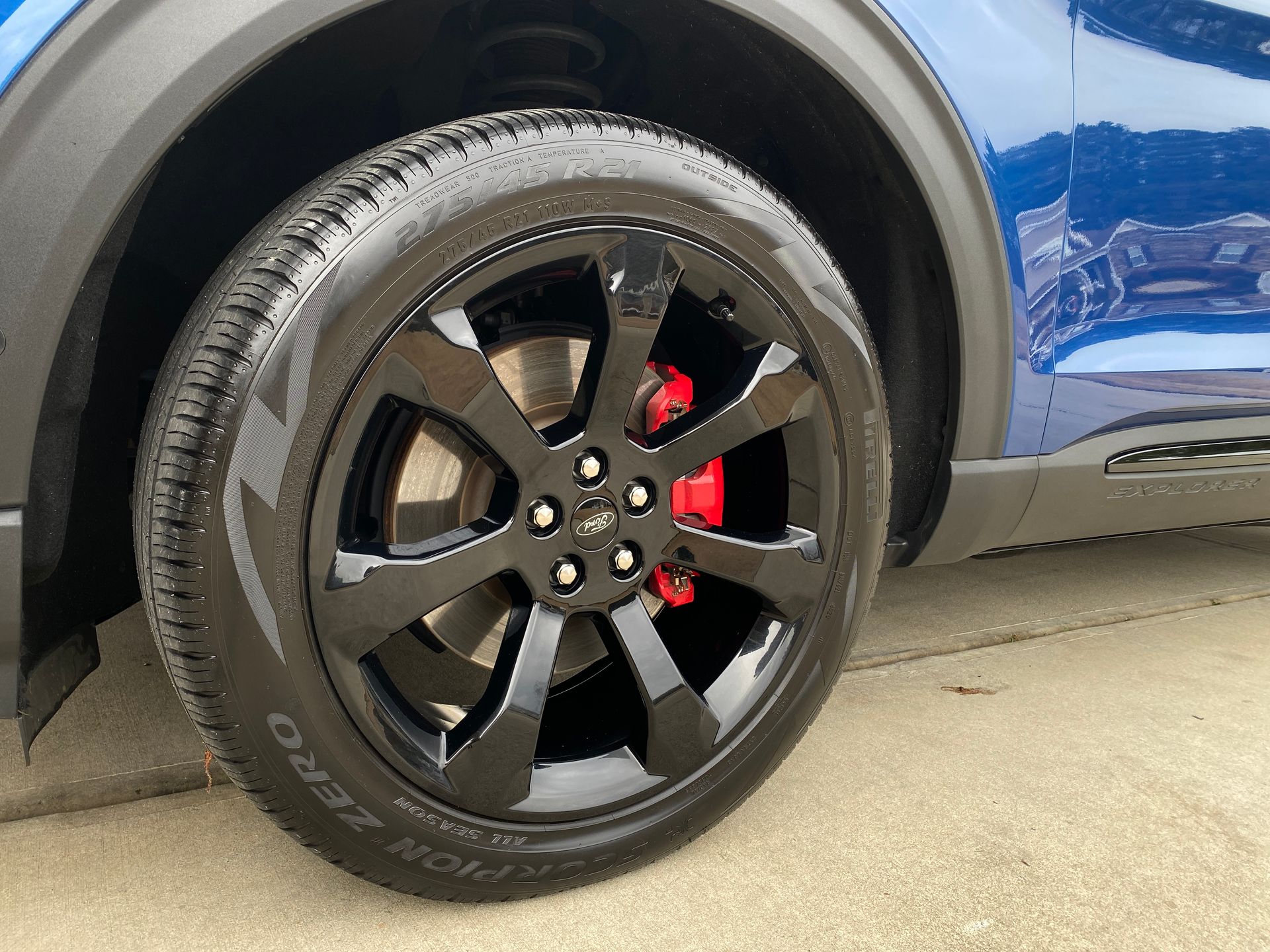 Black car wheel with red brake calipers.