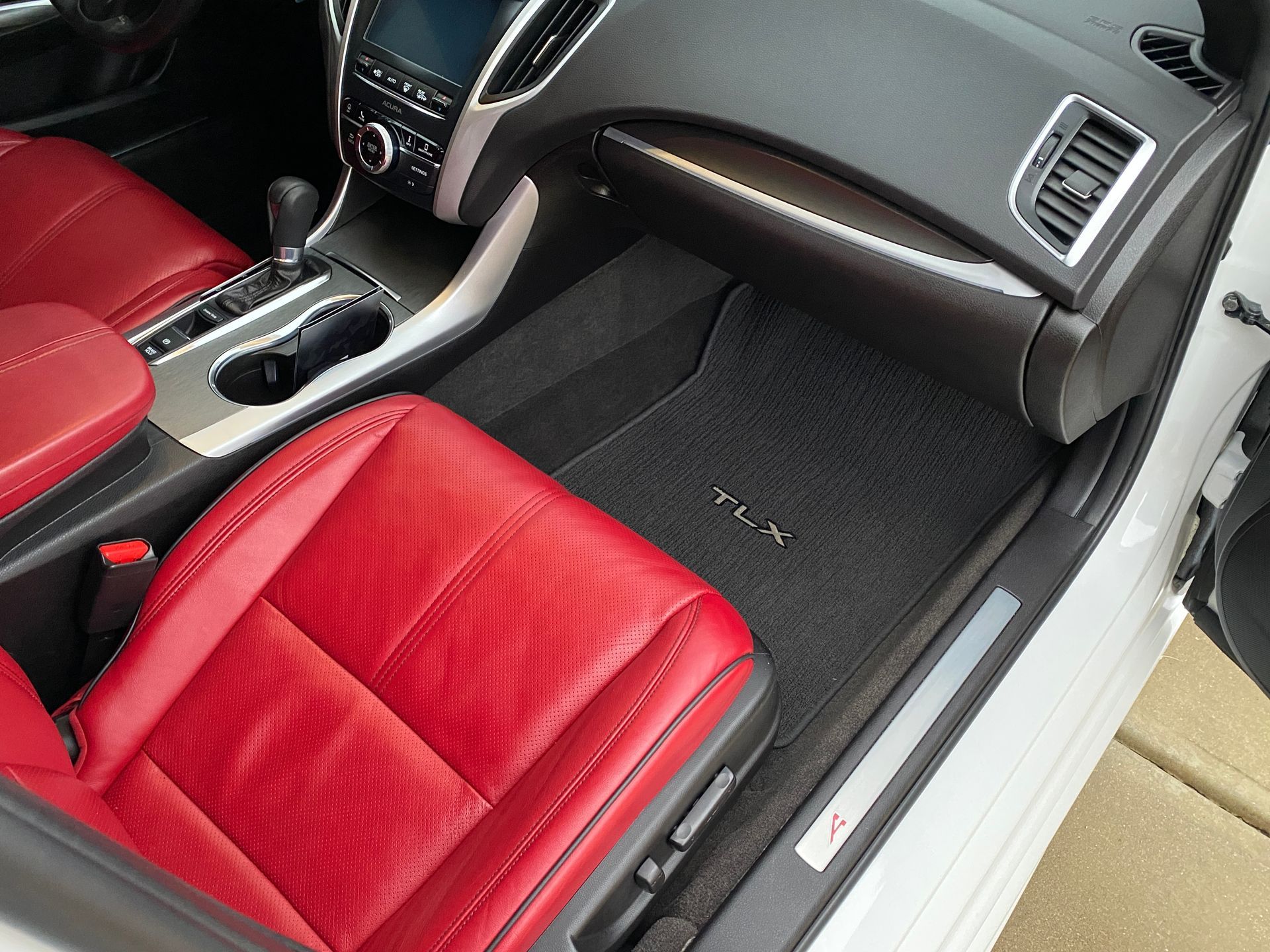 Red leather car interior with gray floor mat.