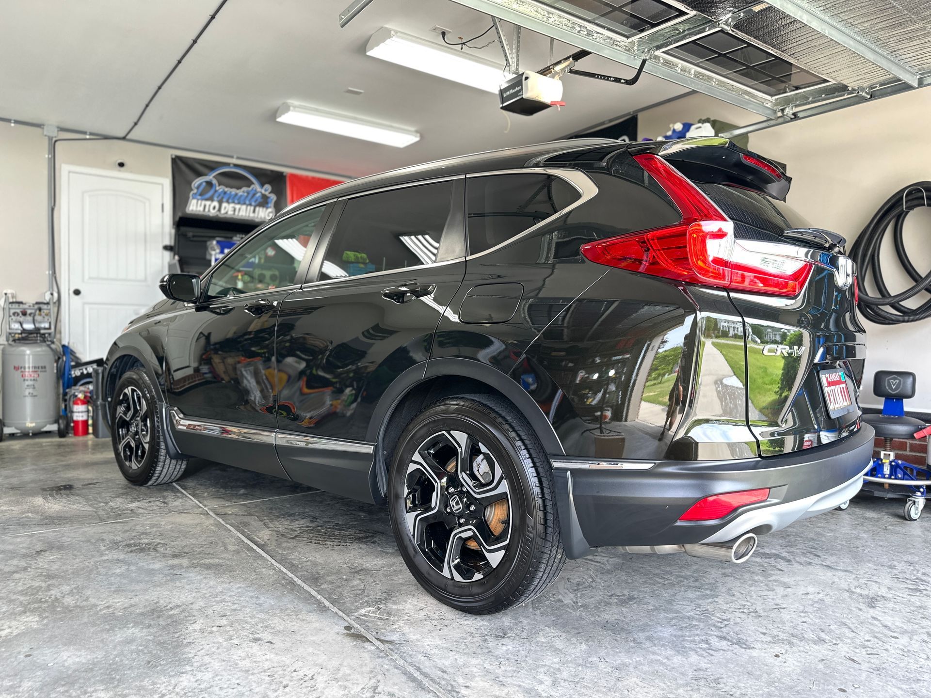 Black Honda CRV parked inside a garage. The vehicle has black wheels, tinted windows, and chrome trim.