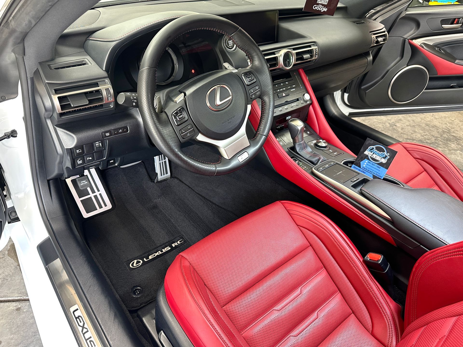 Interior of a Lexus RC car. Red leather seats, black steering wheel, dashboard, and floor mats.