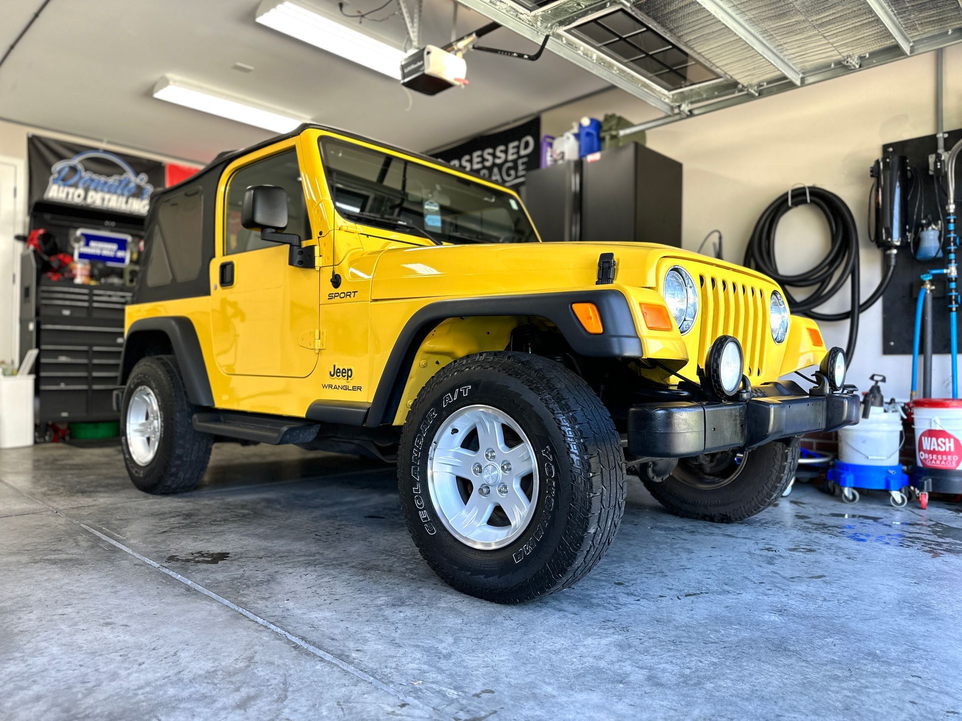 Yellow Jeep Wrangler parked in a garage.