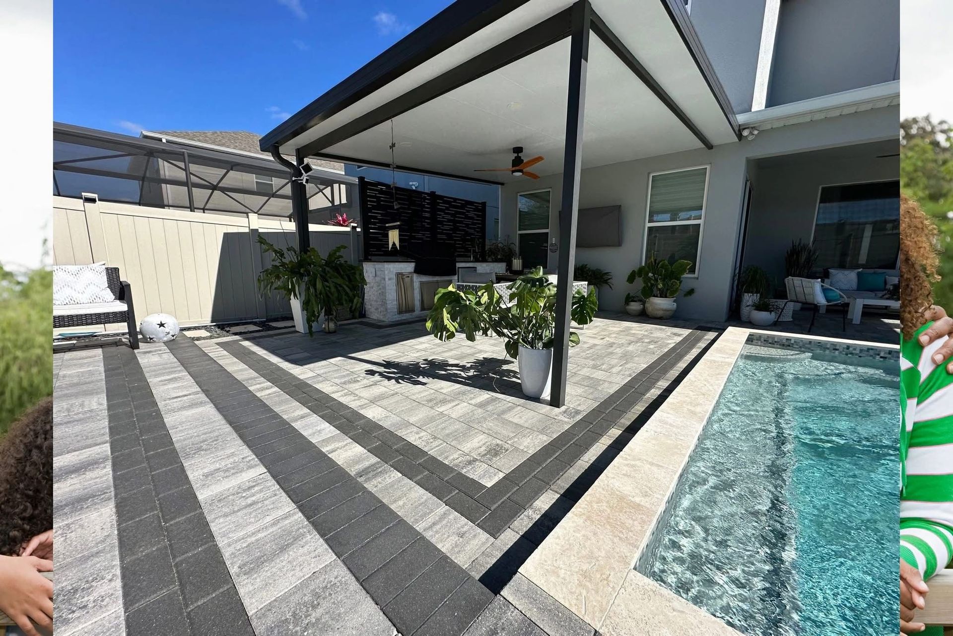 Modern patio with gray pavers, black pergola posts, potted plants, and a blue-tiled pool beside a house
