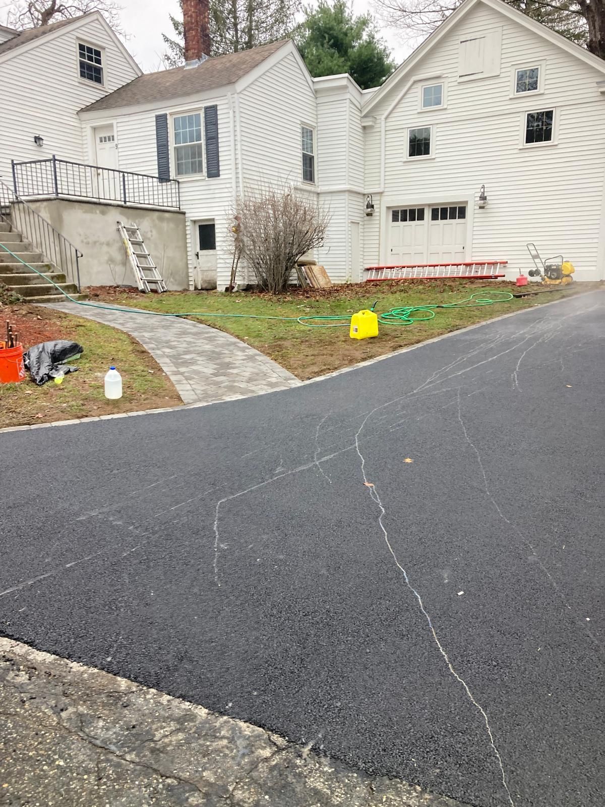 Suburban house with a curved driveway, stone walkway, and a garage in overcast weather