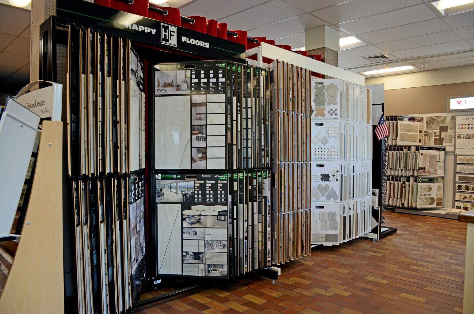 Flooring showroom with display racks of carpet and tile samples under bright indoor lighting