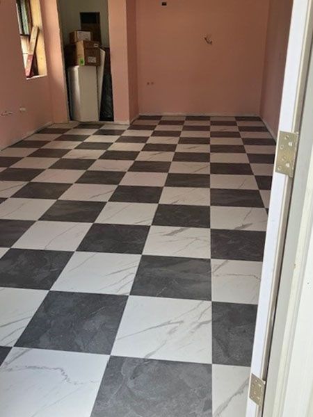 A room with a black and white checkered tile floor, pink walls, and an open door.