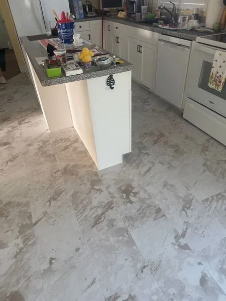 Kitchen with white cabinets and island; concrete floor visible.