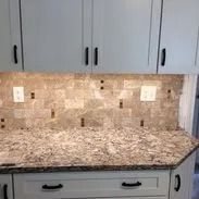 Kitchen with light blue cabinets, brown granite countertop, mosaic backsplash.