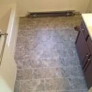 Bathroom with gray tile floor, white tub, and purple vanity.