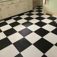 Black and white checkered kitchen floor with white cabinets in the background.