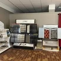 Interior design display with flooring and cabinet samples on shelves.