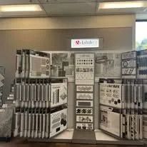 Display of tile samples in a store, featuring a variety of colors and patterns.