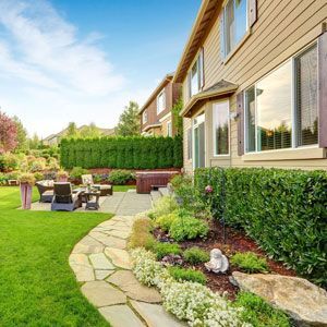A large house with a lush green lawn and a stone walkway leading to it