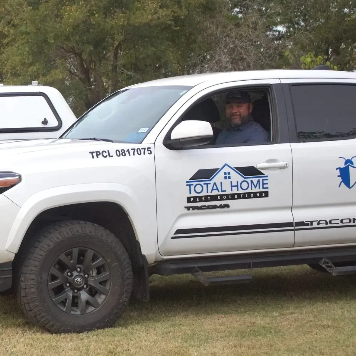 White Total Home Pest Solutions truck with a driver.