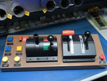 Brown control panel with levers, buttons, and switches, likely for a flight simulator