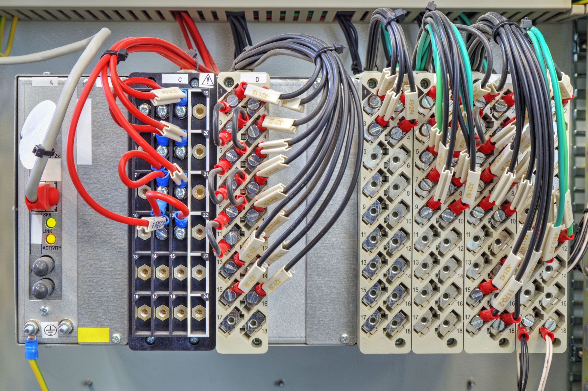 Electrical control panel with dense red, blue, gray, and black wiring connected to terminal blocks