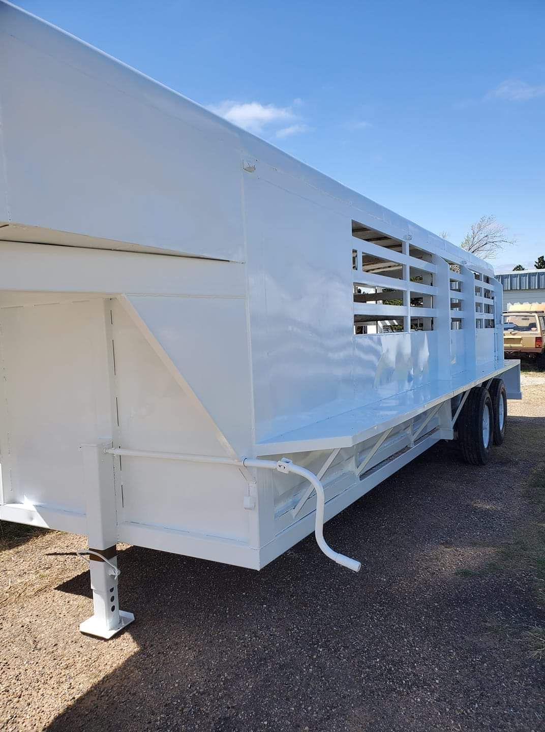 A white trailer is parked on the side of the road.