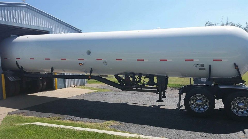 A large white tanker truck is parked in a parking lot.