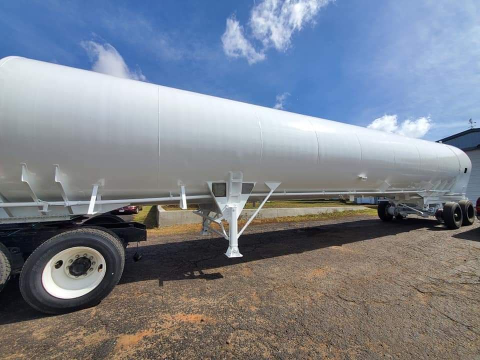 A large white trailer is parked on the side of the road.