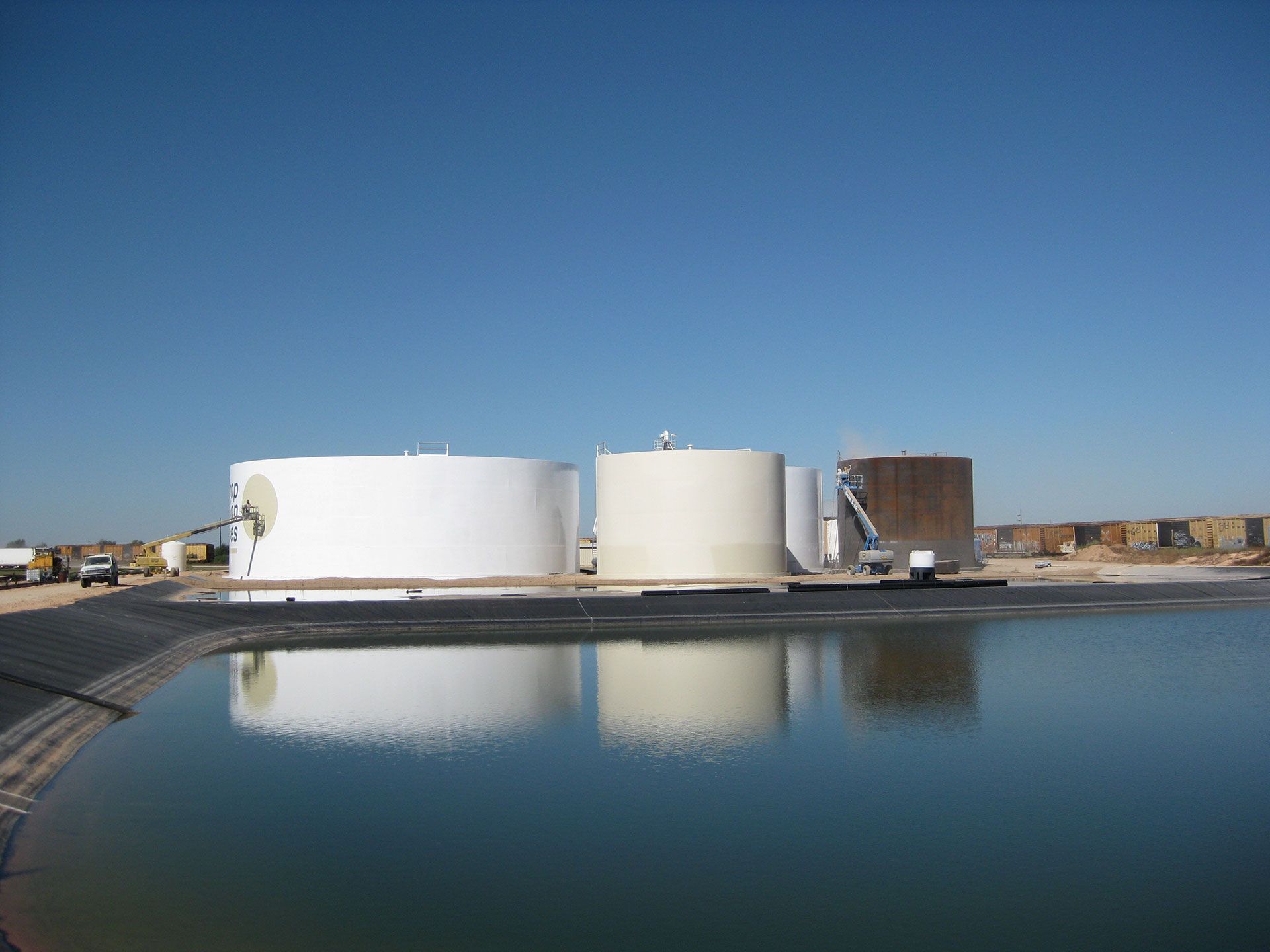 A group of tanks are sitting next to a body of water