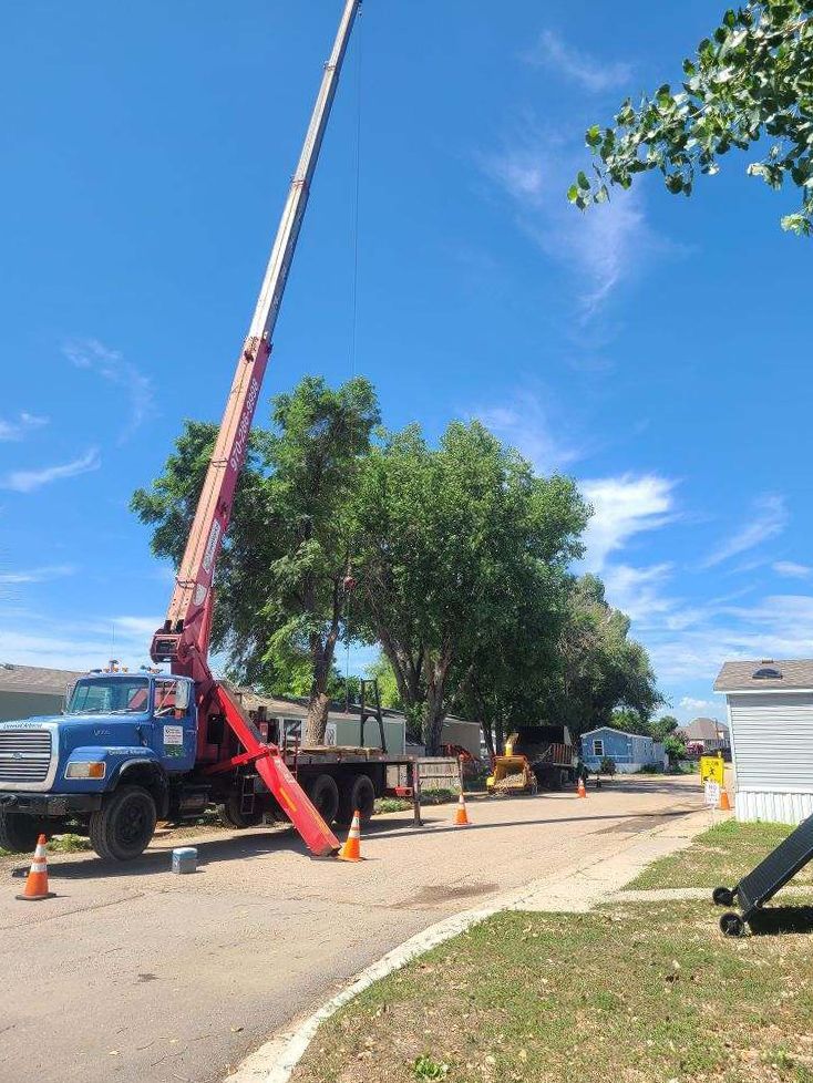 A crane is sitting on top of a truck on the side of the road.
