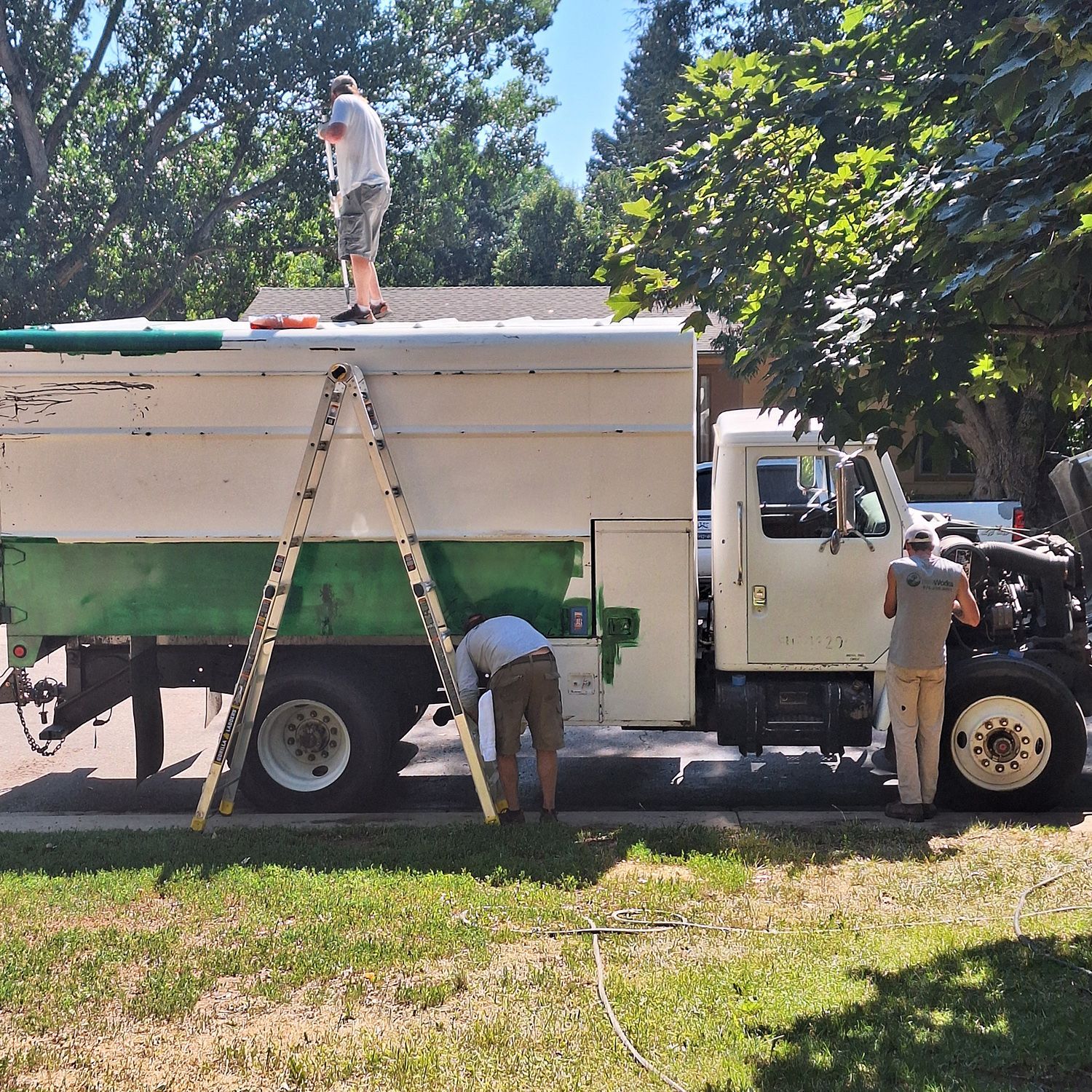 Two men are working on the roof of a truck
