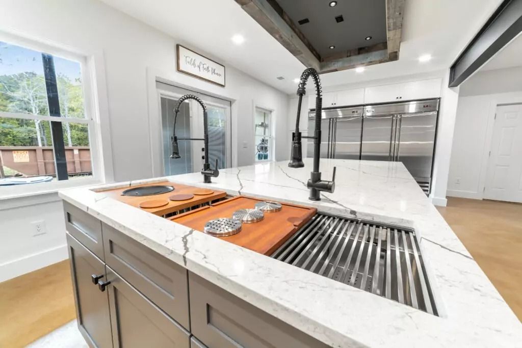 A kitchen with stainless steel appliances and a large sink.