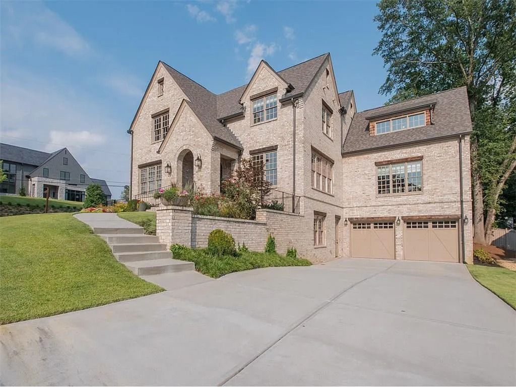 A large brick house with two garages and stairs leading up to it.