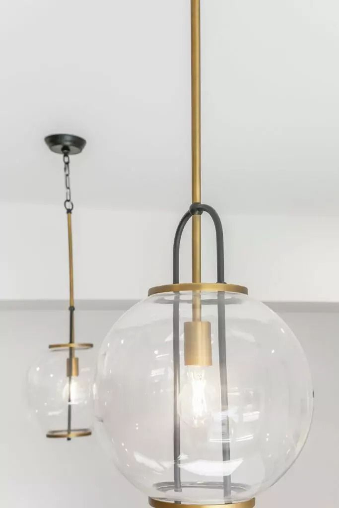 A close up of two pendant lights hanging from the ceiling.