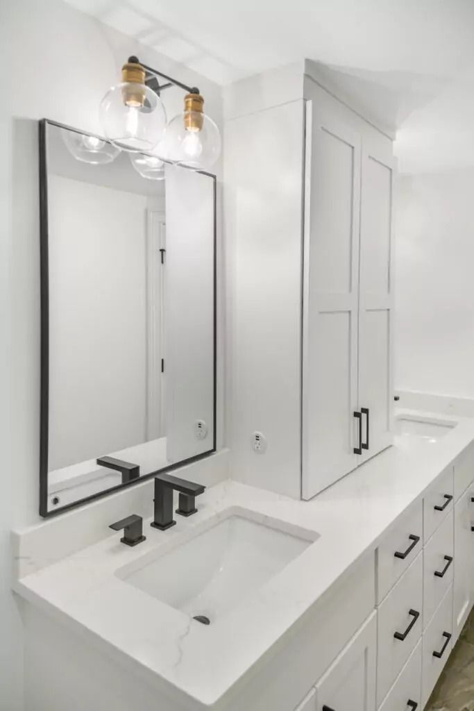 A bathroom with two sinks and a mirror.