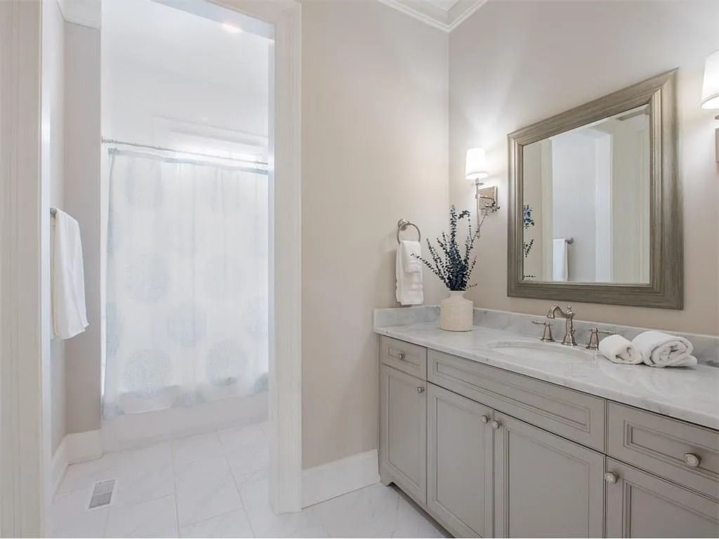 A bathroom with two sinks , a mirror and a shower.