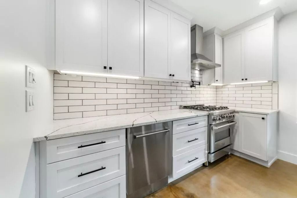 A kitchen with white cabinets and stainless steel appliances.