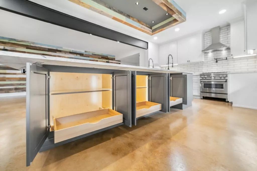 A kitchen with a lot of cabinets and drawers open.