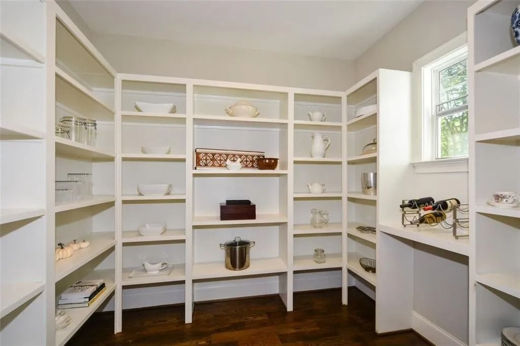 A pantry with lots of shelves and a window