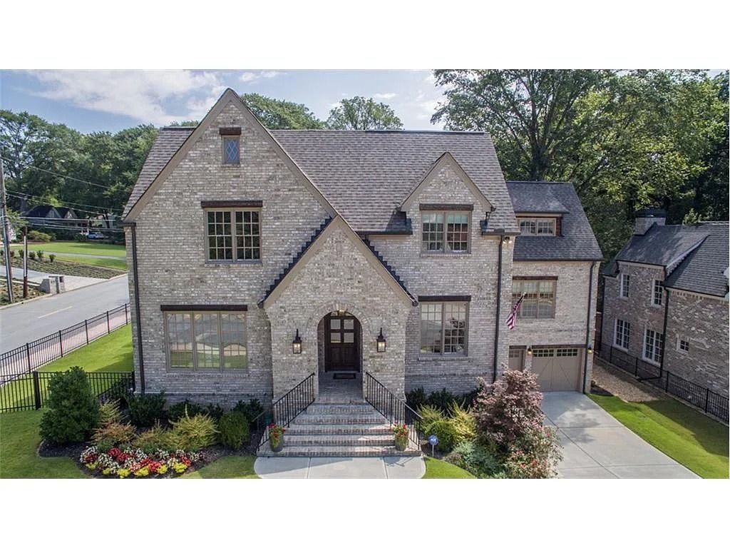 An aerial view of a large brick house surrounded by trees.