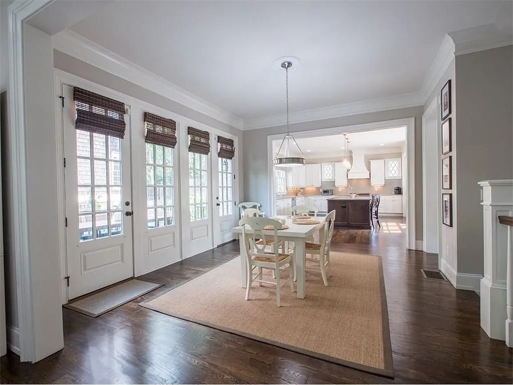 A dining room with a table and chairs and a rug.