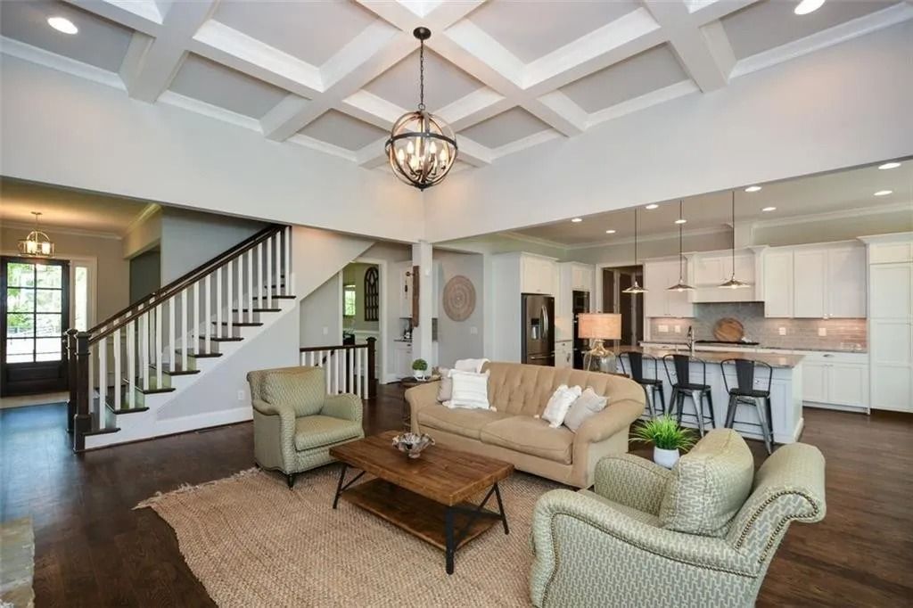A living room with a couch , chairs , coffee table and stairs