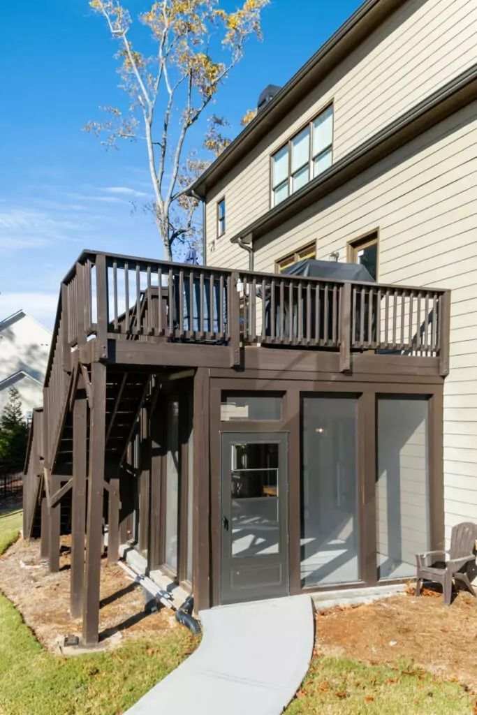A house with a large deck and a walkway leading to it.