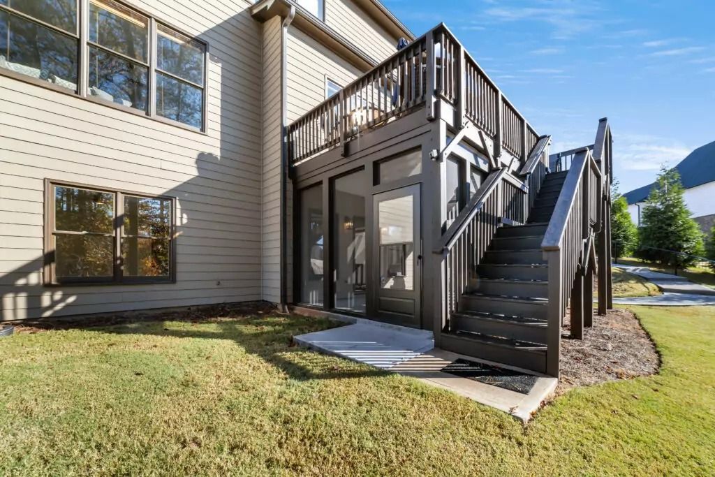 A large house with a large deck and stairs leading up to it.