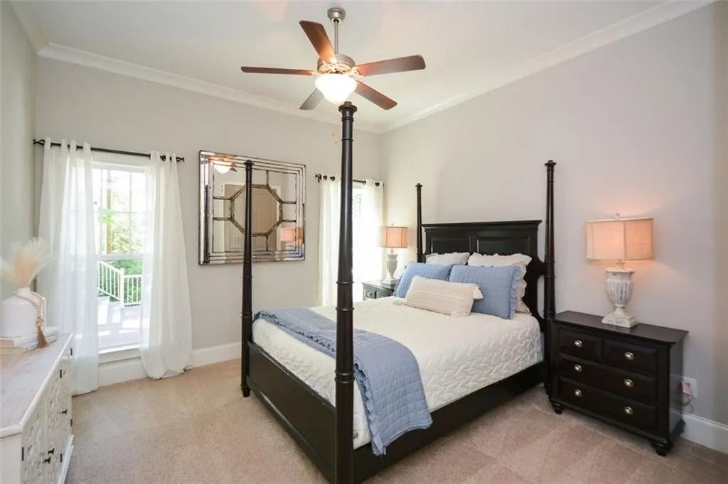 A bedroom with a four poster bed and a ceiling fan
