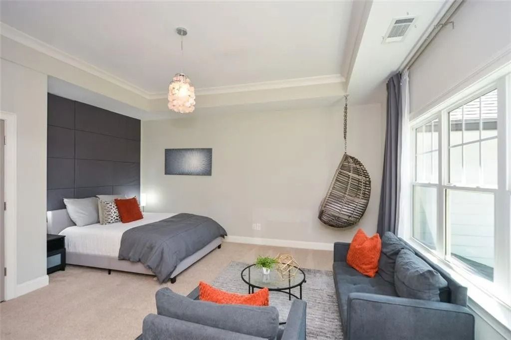 A bedroom with a bed , couch and chairs